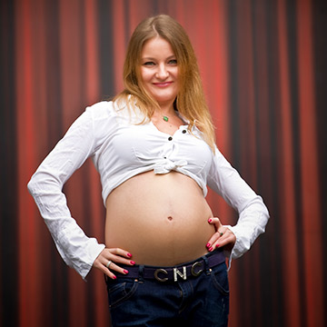 Eine schwangere Frau lächelt. Schwangerschaftsfoto.