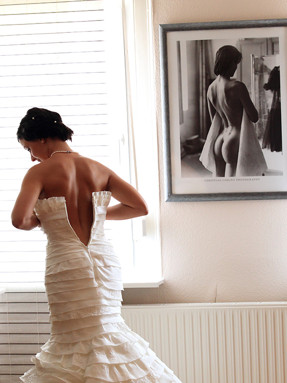Braut zieht das Kleid an. Hochzeitsportrait. Getting ready.